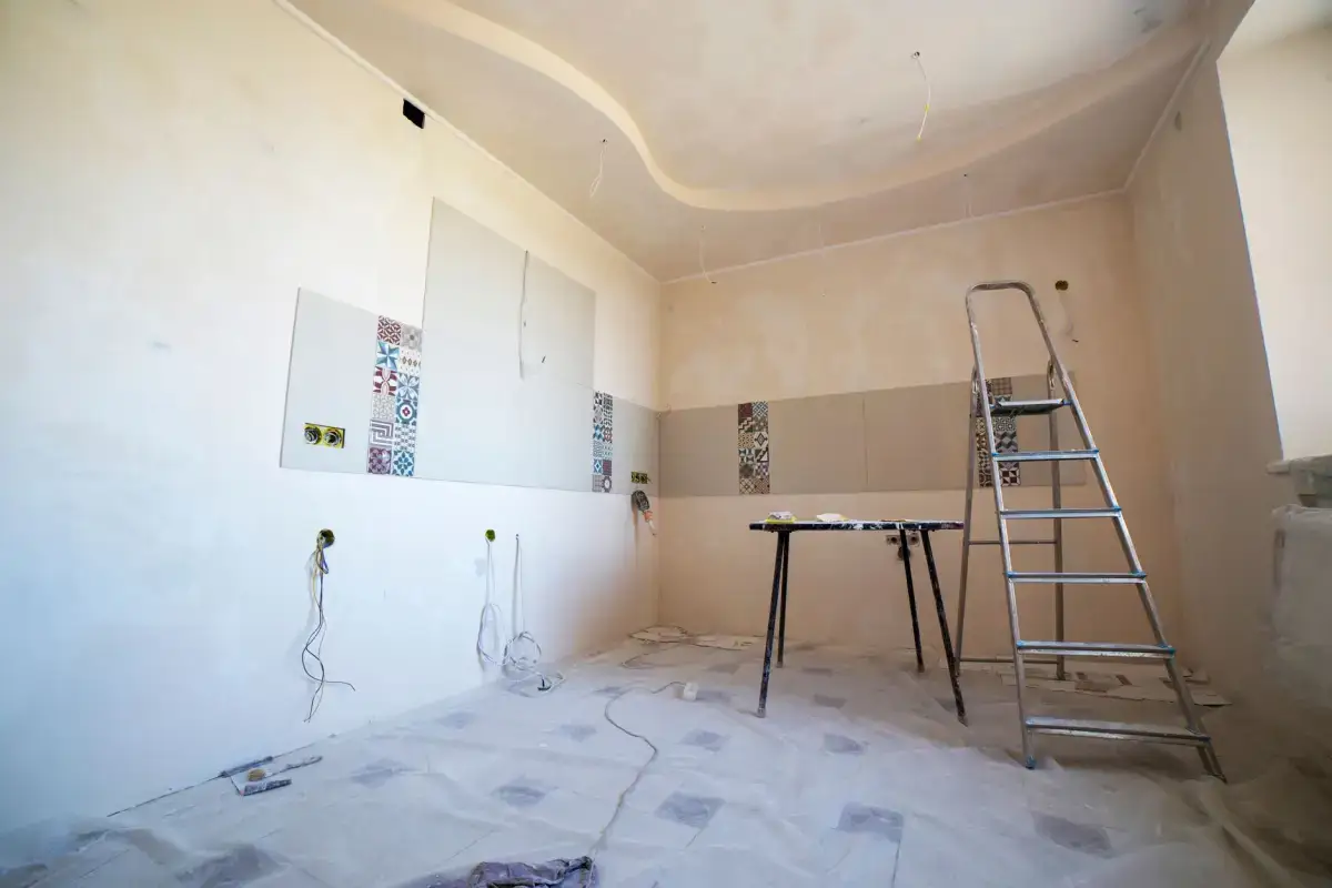 Room set up for ceiling repair with floors covered and finishing tools laid out