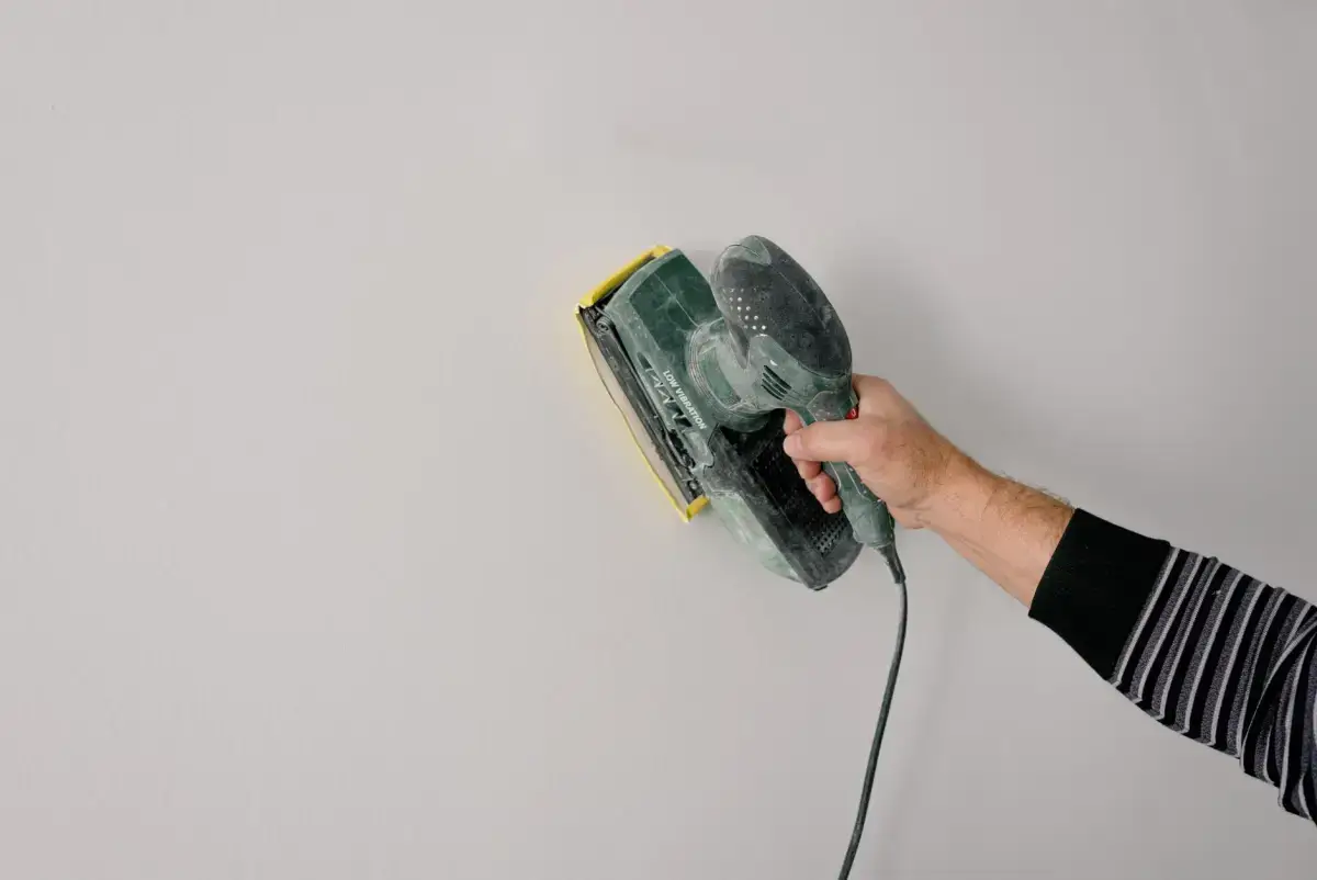 Joint compound being drawn smooth across a seam with a finishing knife