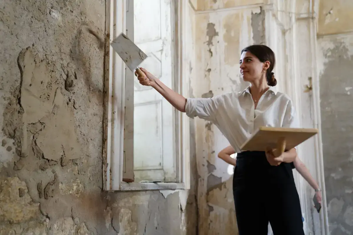 Plaster being worked into a damaged wall section during a plaster repair in an older Davenport home