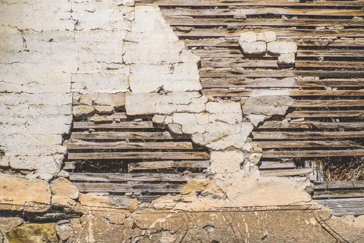Exposed wood lath behind failed plaster on an interior wall in an older Moline, Illinois home